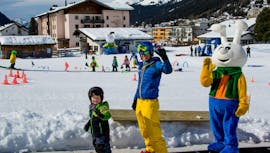 Un niño se ríe durante las Clases de esquí para niños "Bünda" (4-7 años) para debutantes con la escuela suiza de esquí de Davos.