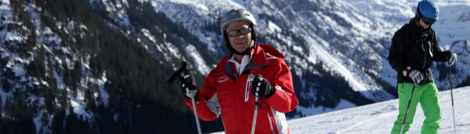 Een skileraar van Skischule Mittelberg op de piste, klaar om volwassen skilessen voor gevorderden te geven.