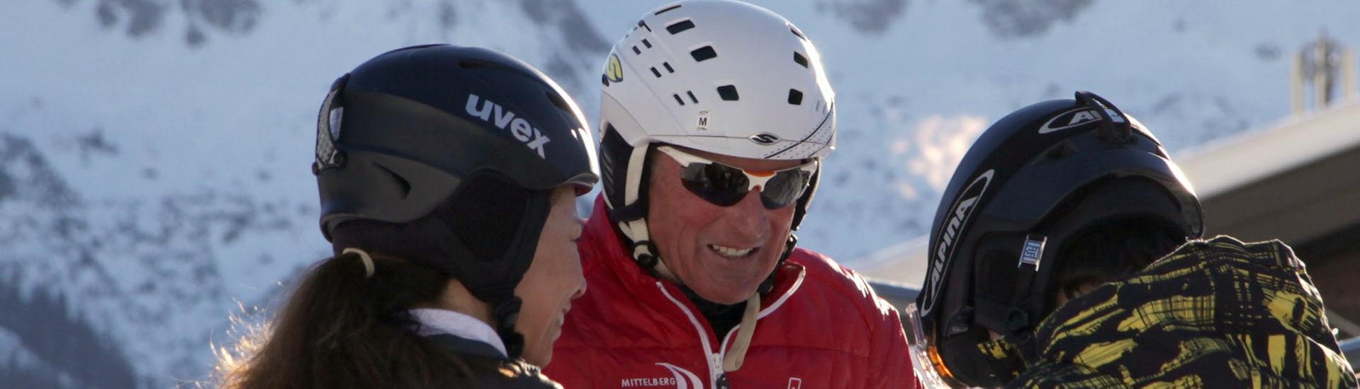 Een instructeur van de Skischool Mittelberg helpt snowboarders tijdens privé snowboardlessen voor kinderen en volwassenen van alle niveaus.