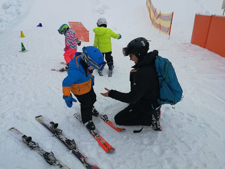 Bambino che sale sugli sci durante le lezioni private o per bambini con Wolfgang.
