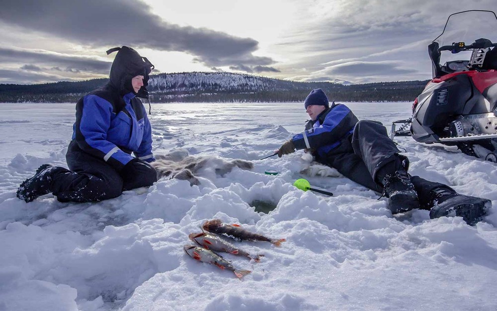 Ganztägige Schneemobil-Tour in Lappland mit Eisfischen und Mittagessen an der Feuerstelle mit Kiruna Guidetur.
