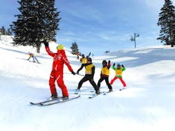 Children follow their instructor during  kids ski lessons for beginners in Crans-Montana with the Swiss Ski School.