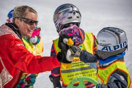 Un istruttore gioca con un bambino durante le lezioni di sci per bambini "BOBOs Baby-Club" (0-2 anni) con lo Ski Dome Oberschneider Kaprun.