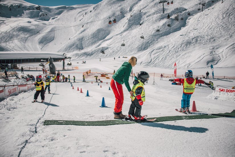 An instructor helping children during Kids Ski Lessons "BOBO's Kinderkurse" (4 y.) for First Timers from Skischule Ski Dome Oberschneider Kaprun..