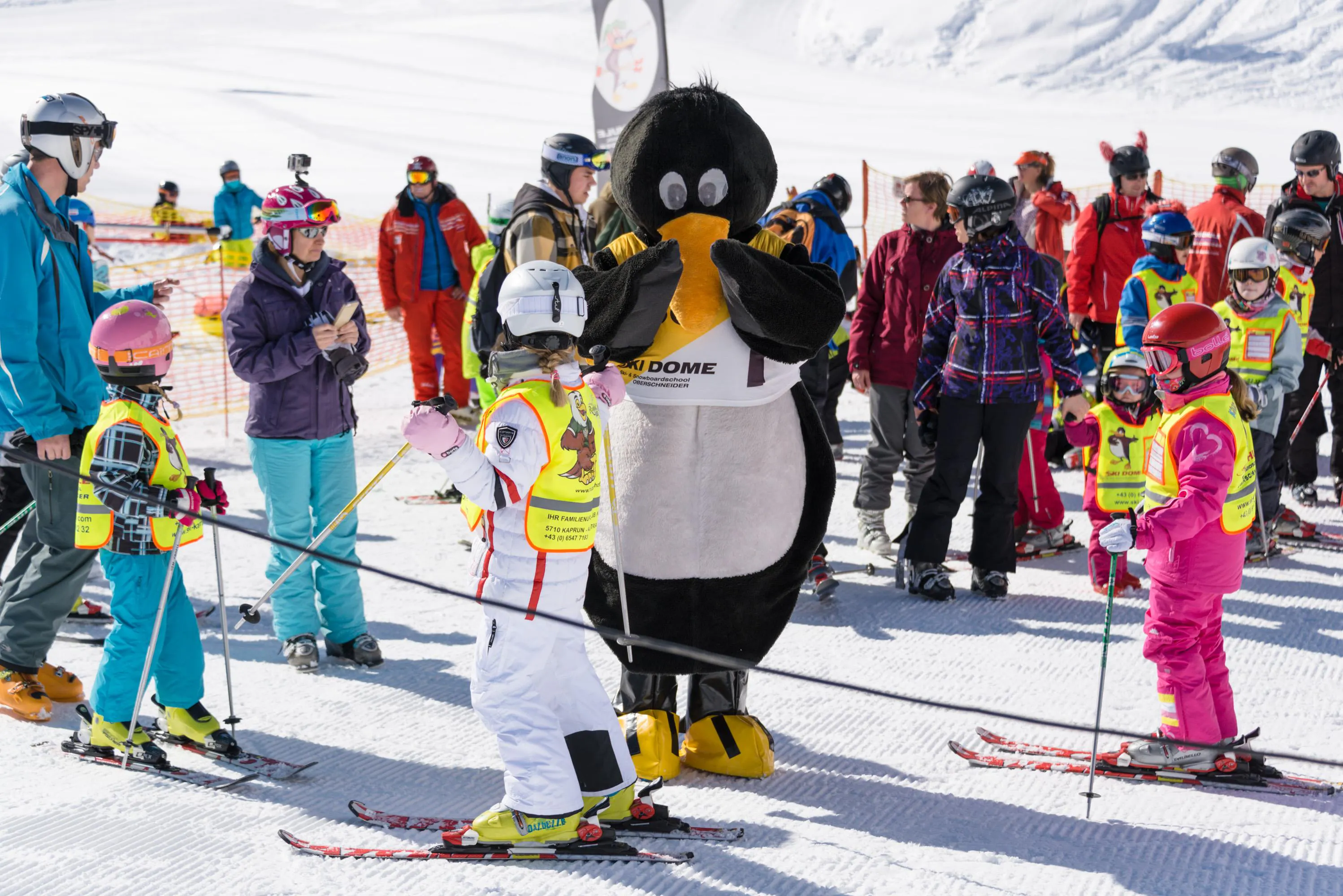 Kinder-Skikurs "BOBOs Kids Club" (4-15 J.) für Fortgeschrittene mit Skischule Ski Dome Oberschneider Kaprun Bobo der Pinguin feuert die Kinder beim Kinder-Skikurs "BOBOs Kids Club" (4-15 J.) für Fortgeschrittene im Ski Dome Oberschneider in Kaprun an.