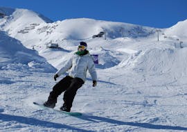 Een snowboarder tijdens de snowboardlessen voor volwassenen voor beginners bij Ski Dome Oberschneider in Kaprun.