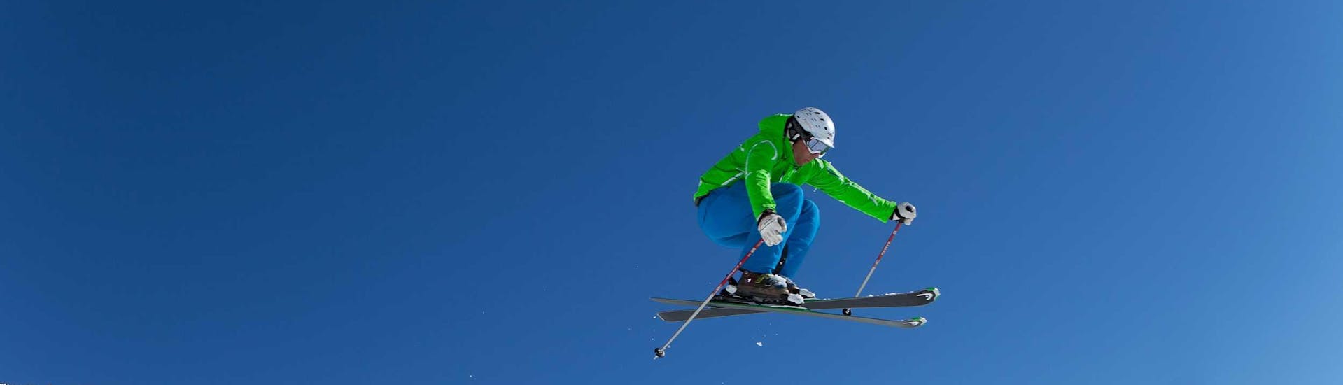 An advanced skier jumping through the air with the help of private ski lessons for adults of all levels with Ski Dome Oberschneider in Kaprun.