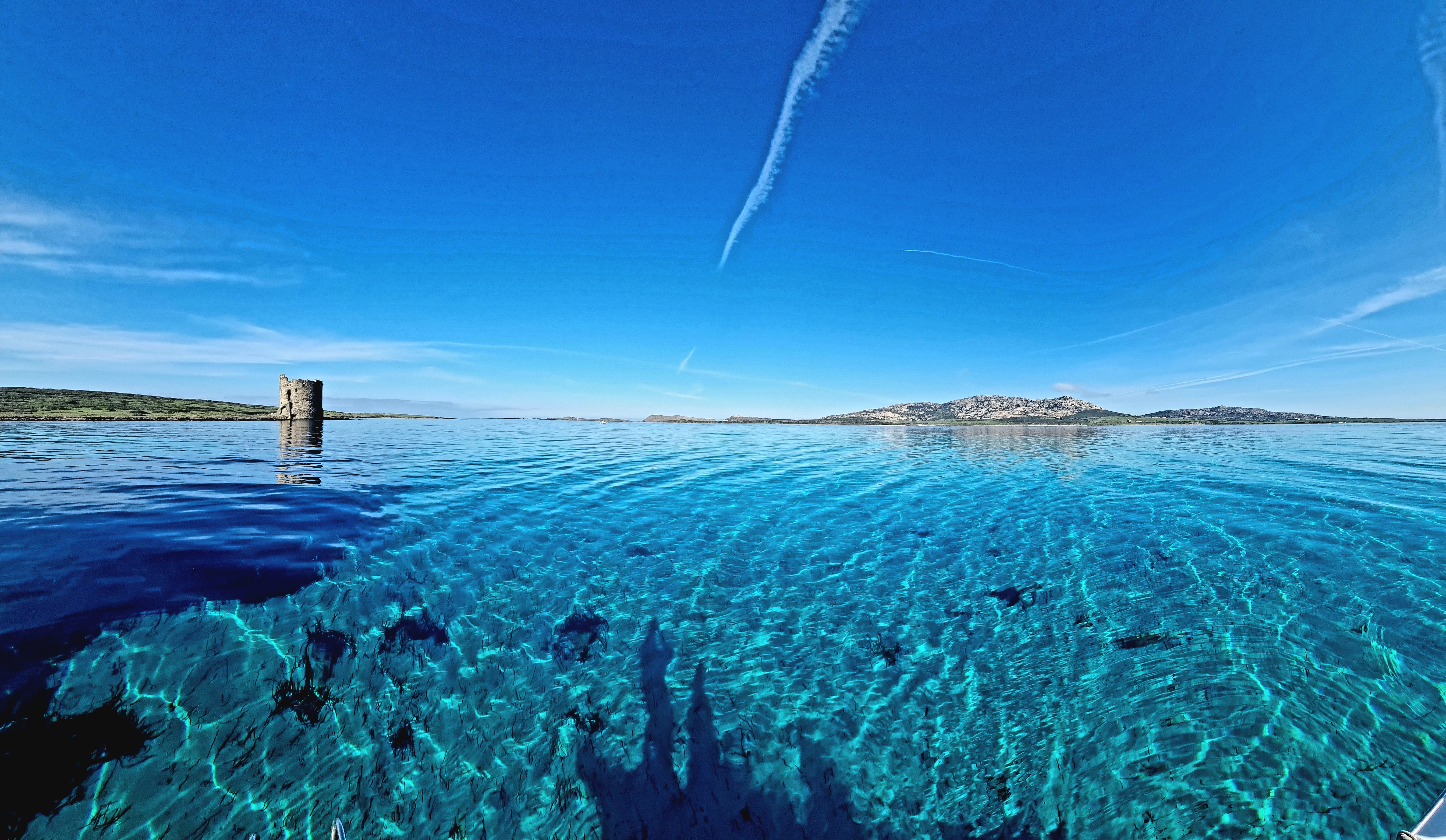 Crystal-clear waters facing La Pelosa Tower in Stintino Crystal-clear turquoise water reveals the seabed near the historic Torre della Pelosa during a half-day rubber dinghy tour from Stintino to Asinara and La Pelosa with Sottovento Escursioni Asinara.