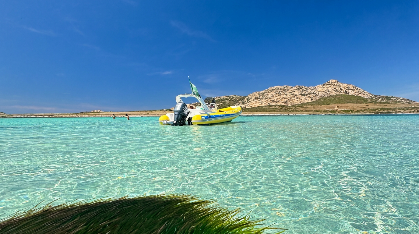 A yellow RIB boat rests on crystal-clear turquoise water during a boat trip from Stintino to the Asinara National Park with Sottovento Escursioni Asinara.
