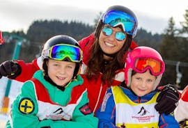 Two children with their instructor during the Private Ski Lessons for Kids of All Ages with the Snow Sports School Eichenhof St. Johann.