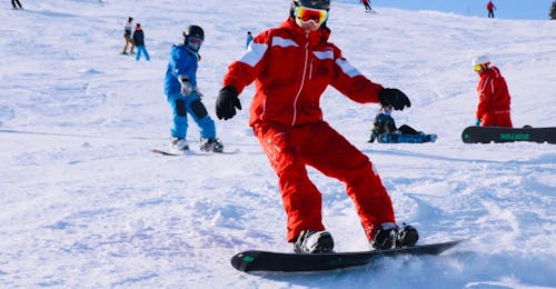 Cours de snowboard Enfants & Adultes pour Expérimentés - Demi-journée avec Snow Sports School Eichenhof St. Johann Un snowboardeur dévalant les pistes pendant les Cours de snowboard pour Enfants & Adultes pour Expérimentés avec l'école de ski Snow Sports School Eichenhof St. Johann.