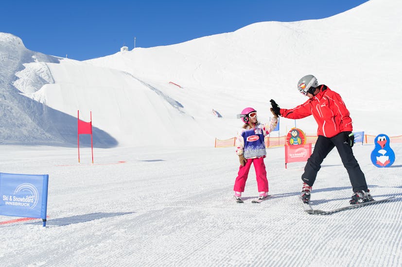 Una niña está feliz con los logros durante las clases particulares  de esquí para niños con Skischule Innsbruck.