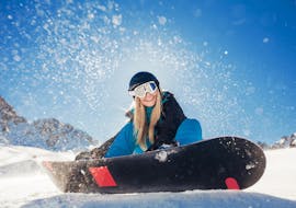 Une fille sourit pendant des cours particuliers de snowboard à la Skischule Innsbruck.