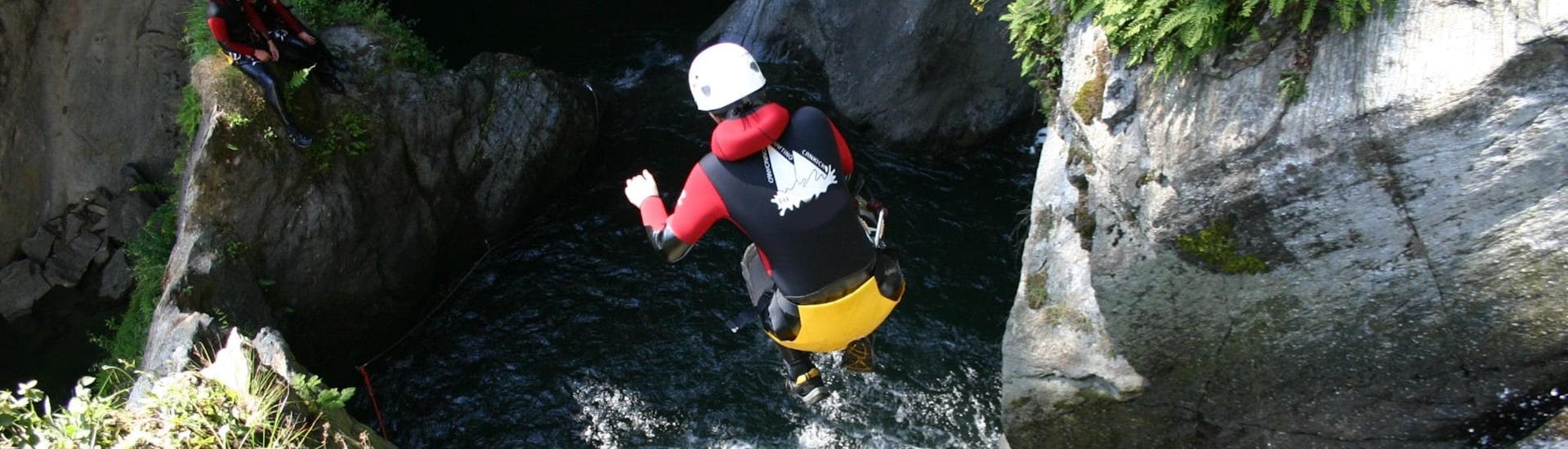 A canyoneer is jumping from a waterfall into a natural pool of water during the tour Canyoning in the Alpenrosenklamm in Ötztal for Beginners with CanKick Ötztal.