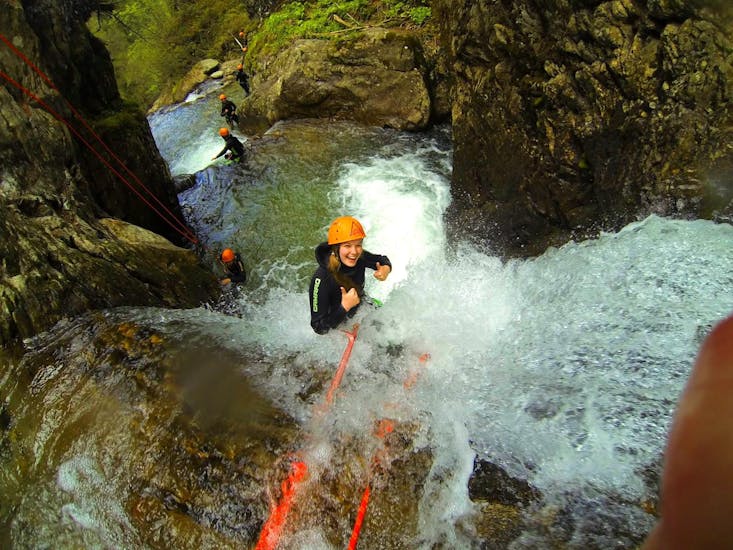 A woman abseiling from a waterfall during the Canyoning in Auerklamm from Haiming - Manitou Tour with Wiggi Rafting Haiming.