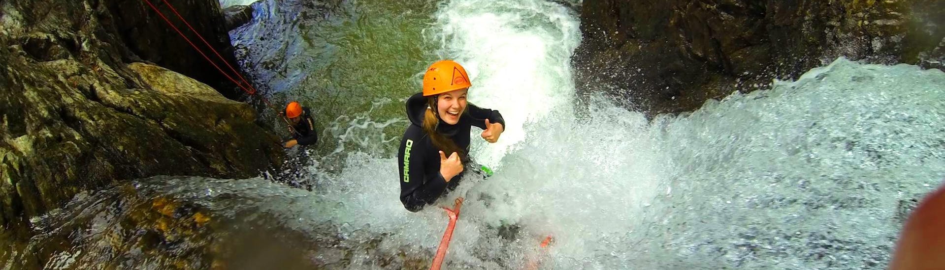 A woman abseiling from a waterfall during the Canyoning in Auerklamm from Haiming - Manitou Tour with Wiggi Rafting Haiming.