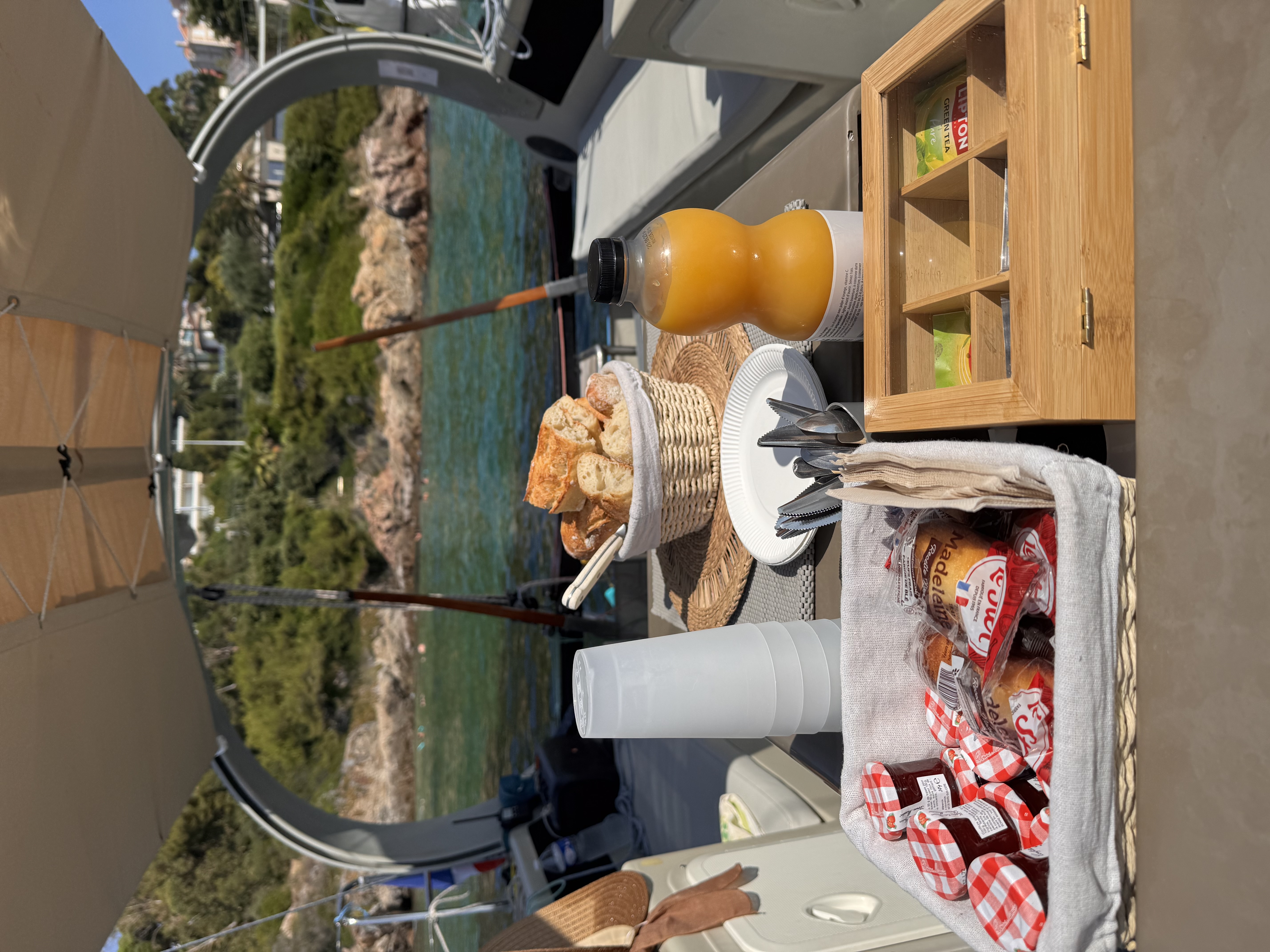 Petit-déjeuner servi à bord d'un bateau lors d'une excursion en voilier Un petit-déjeuner composé de pain frais, de viennoiseries et de jus de fruits est servi à bord d'un voilier lors d'une excursion en mer à Antibes, avec une halte pour une baignade organisée par Cap Sail Aventures Antibes.