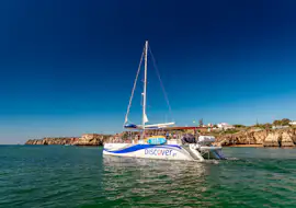 Crucero en catamarán por la costa de Ponta da Piedade Un catamarán AlgarExperience lleno de invitados navega a lo largo de la costa de Ponta da Piedade en un día soleado durante el tour en catamarán Lagos: Cuevas de Ponta da Piedade.