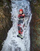 A woman sliding down a waterfall while Canyoning in Alpenrosenklamm - Sports Tour with feelfree Outdoor Professionals Ötztal.