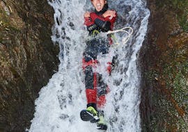 Een vrouw glijdt van een waterval tijdens canyoning in de Alpenrosenklamm - Sporttour met Feelfree Outdoor Professionals Ötztal.