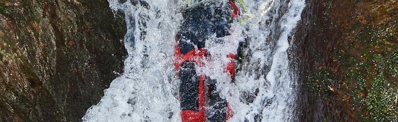 Een vrouw glijdt van een waterval tijdens canyoning in de Alpenrosenklamm - Sporttour met Feelfree Outdoor Professionals Ötztal.