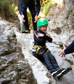 A kid slides down a natural slide while Canyoning for Families near Ried im Oberinntal with H2O Adventure Ried.
