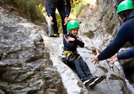 Ein Kind rutscht eine natürliche Rutsche beim Canyoning für Familien bei Ried im Oberinntal mit H2O Adventure Ried hinunter.