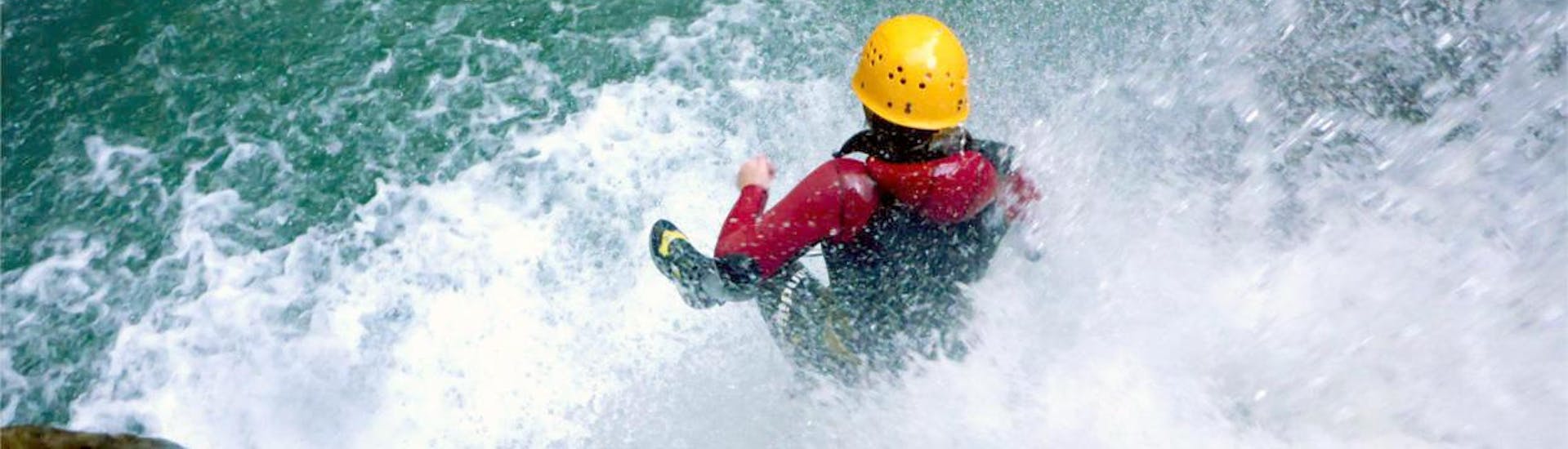 A costumer sliding into the water during Fun Canyoning in Starzlachklamm from Sonthofen with Die Canyonauten Allgäu
