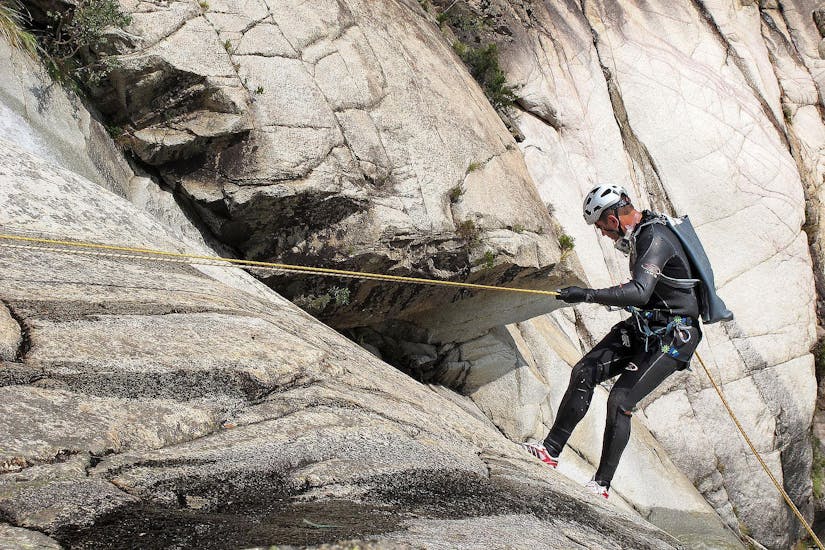 Beim Canyoning für Einsteiger am Sylvensteinsee klettert ein Teilnehmer unter den wachsamen Augen eines zertifizierten Canyoning-Guides von Montevia eine Felswand hinunter.