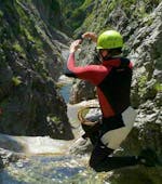 Beim Canyoning für Einsteiger am Sylvensteinsee springt ein Teilnehmer unter den wachsamen Augen eines zertifizierten Canyoning-Guides von Montevia in ein natürliches Becken.