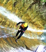 A participant of Extreme Canyoning at Lake Sylvenstein with Montevia is abseiling down a waterfall in the canyon.