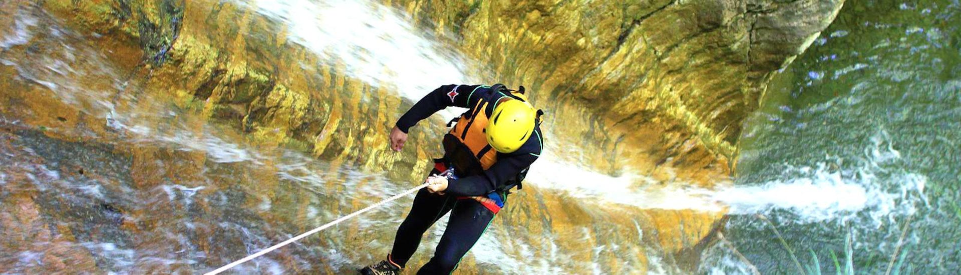 A participant of Extreme Canyoning at Lake Sylvenstein with Montevia is abseiling down a waterfall in the canyon.