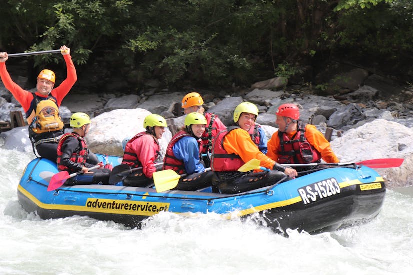 Participants sit in the raft with a guide and have fun during the rafting tour on the Saalach with Adventure Service Outdoorsports.