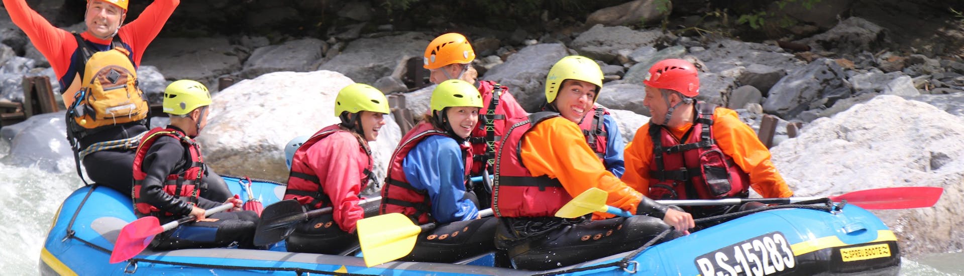 Participants sit in the raft with a guide and have fun during the rafting tour on the Saalach with Adventure Service Outdoorsports.