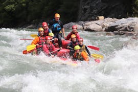 A group of friends sit in a boat with the guide and go rafting on the Salzach River near Zell am See with Adventure Service Outdoorsports.