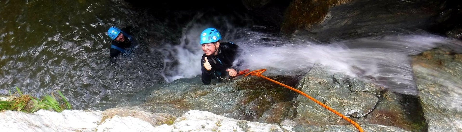 A young boy is having fun while abseiling over a waterfall during the Canyoning for Kids in the Waterfall Park with FROST.