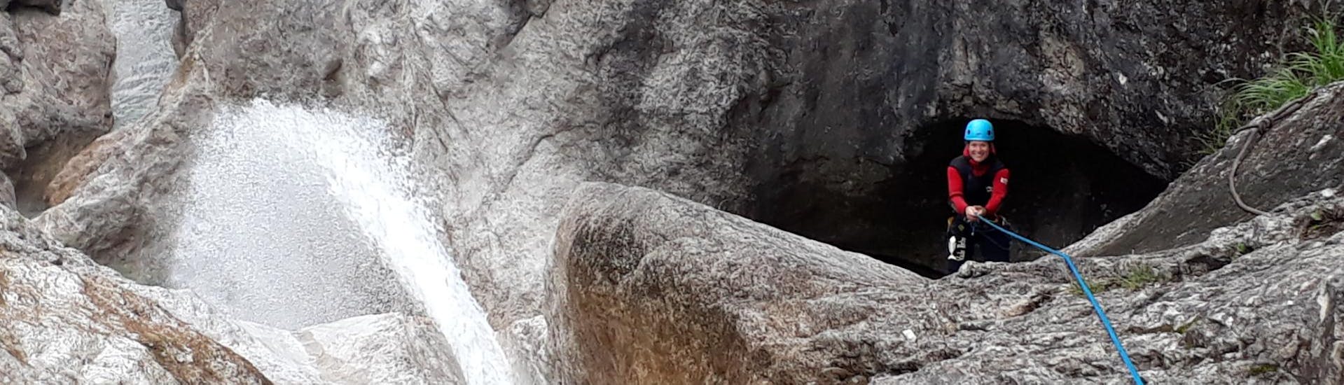 Tijdens de Canyoning for the Brave - Vertical Valley wordt een vrouw opgewonden terwijl ze onder begeleiding van een staatsgediplomeerde canyoninggids Bergführer Salzburg abseilt naar beneden in een canyon.