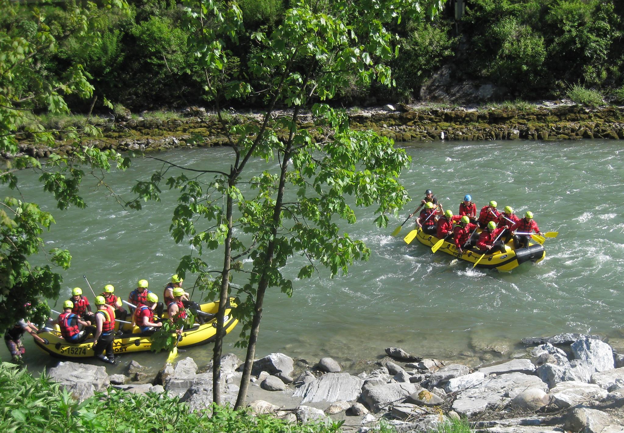 Two rafting groups paddling along the Salzach River in their Rafting Day Tour for Adventurers with the experienced instructors of Frost Rafting & Canyoning Tours. 