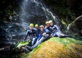 The participants of the tour Canyoning for Families - Zemmschlucht with Mountain Sports Mayrhofen are sitting on a rock for a group photo.