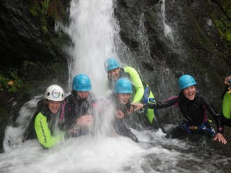People under a waterfall while Canyoning in East Tyrol - Sports Tour with Adventurepark Osttirol.