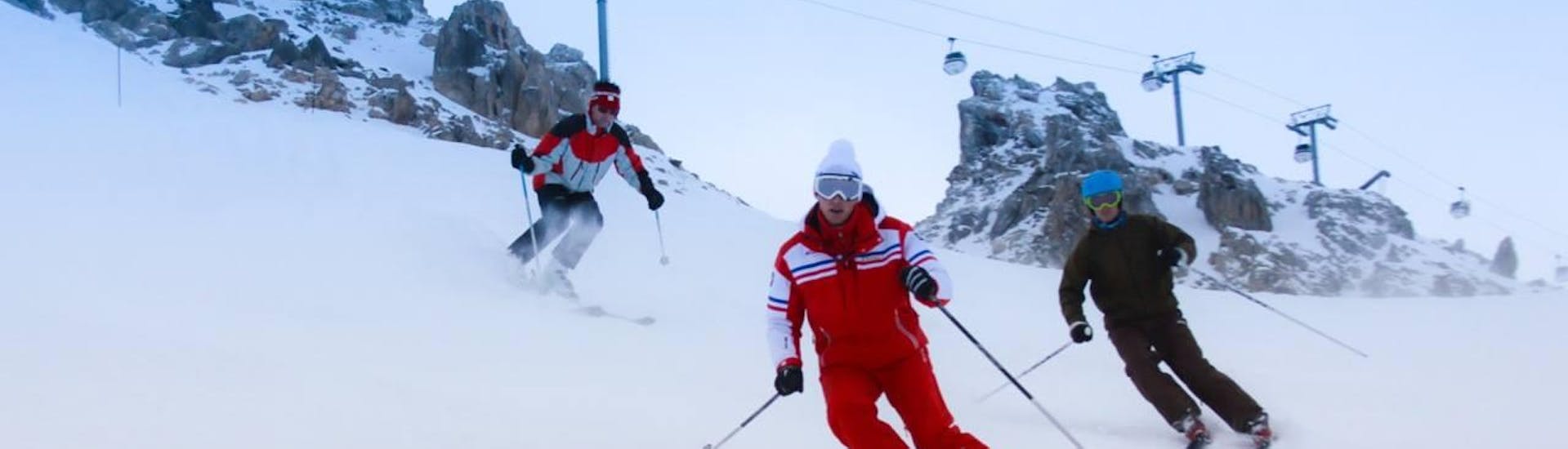 An instructor from the ESF Courchevel accompanies a group during a ski lesson for adults. 