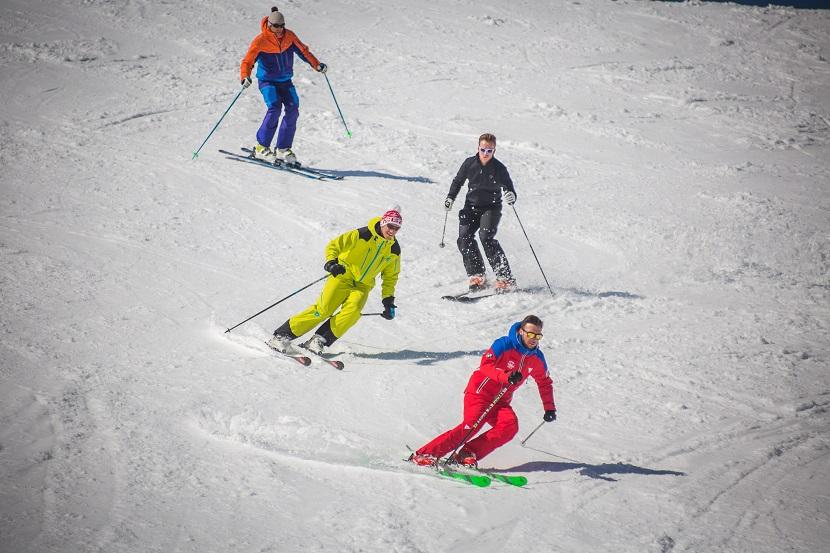 A group of skiers follow an instructor from the ESF Courchevel during a ski lesson for adults. 