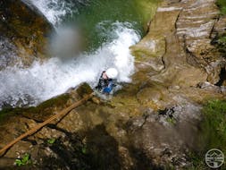 Beim Canyoning "Rocks & Ropes" für sportliche Einsteiger mit Base Camp seilt sich ein Teilnehmer über einen Wasserfall ab.