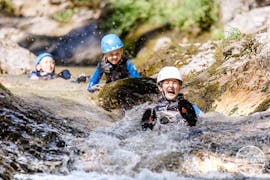 Three kids are having fun as they slide on a natural waterslide during the Canyoning "Kids Rock!" - Discoverer's Canyon with Base Camp.