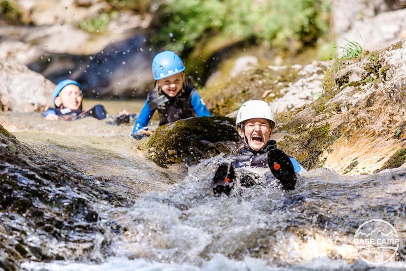 Three kids are having fun as they slide on a natural waterslide during the Canyoning "Kids Rock!" - Discoverer's Canyon with Base Camp.