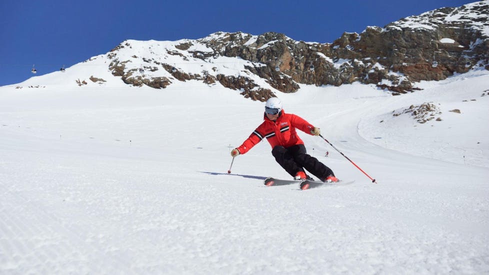Ein Skilehrer der Ski- und Snowboardschule Vacancia demonstriert beim Skikurs für Erwachsene - Alle Levels die richtige Skitechnik.