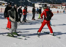 Een skileraar van de skischool Skischule Lechner in Zell am Ziller laat een groep volwassenen zien hoe ze moeten skiën tijdens hun Skilessen voor volwassenen voor Beginners.