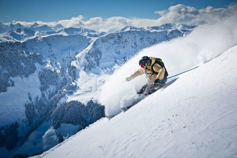 Ein Skifahrer fährt den Berg hinunter, während eines privaten Skikurses für Erwachsene aller Levels mit der Snowacademy Saalbach. 