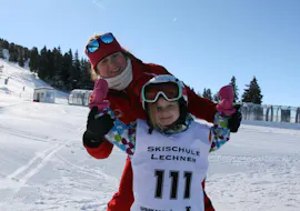 Kids Ski Lessons (5-14 y.) for First Timers from Skischule Lechner Zell am Ziller A young girl and her ski instructor from the ski school Skischule Lechner are smiling at the camera during the Kids Ski Lessons for Beginners (5-14 years).