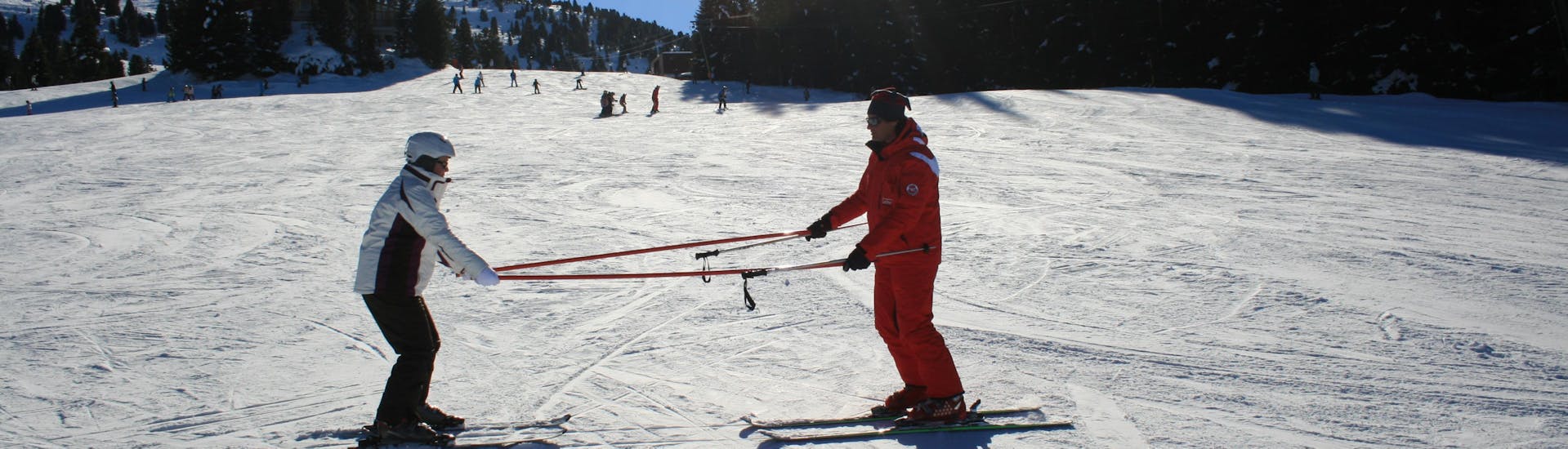 Een beginnende skiër oefent enkele basistechnieken met zijn skileraar van de skischool Skischule Lechner tijdens de privé skilessen voor volwassenen van alle niveaus.